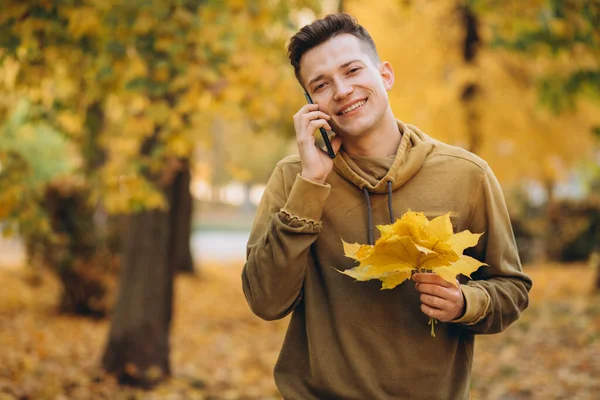 Sonbahar Parkında Gülümseyen Telefonda Konuşan Yakışıklı Mutlu Bir Adamın Portresi — Stok fotoğraf
