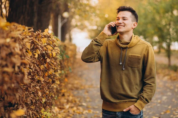 Sonbahar Parkında Gülümseyen Telefonda Konuşan Yakışıklı Mutlu Bir Adamın Portresi — Stok fotoğraf