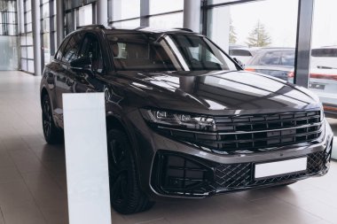 Modern suv parked in a showroom with a blank banner for advertising, representing the automotive industry and car sales