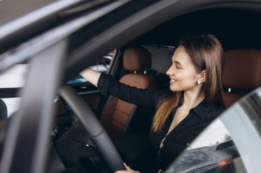 Customer testing a new car in a dealership while holding the steering wheel