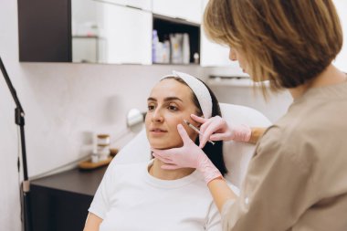 Beautician administering botox injections on a patient's face in a professional clinic, enhancing beauty and promoting youthful skin