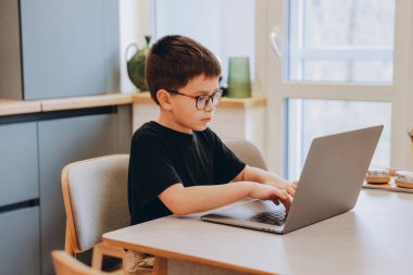 Elementary school student learning online using laptop computer at home, concept of homeschooling, online education and distance learning