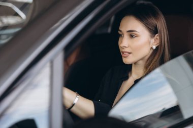 Businesswoman testing a new car in a car dealership
