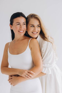 Smiling mother and daughter embracing each other, radiating love and connection while enjoying a joyful moment together in a serene setting