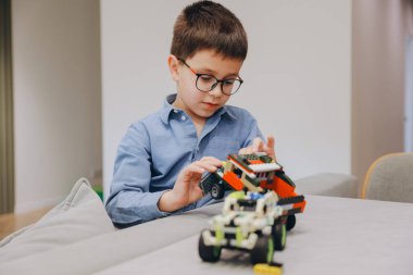 Child playing with building blocks, developing fine motor skills and problem solving abilities in a comfortable home environment
