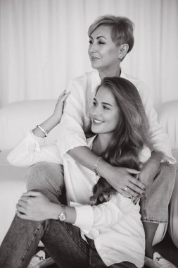 Mother and daughter are embracing on a sofa, creating a heartwarming scene of familial love and connection