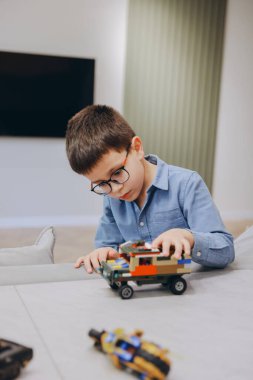 Child playing with colorful building blocks, developing creativity and motor skills in a comfortable home environment