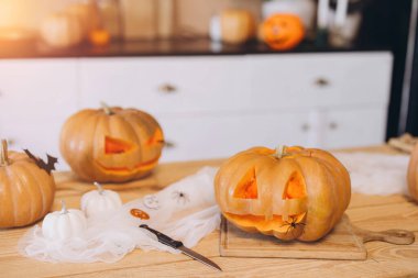 Komik yüzlerle oyulmuş balkabakları örümcekler ve yarasalarla süslenmiş haldeler. Mutfaktaki ahşap bir masada, Cadılar Bayramı gecesi için hazırlar.