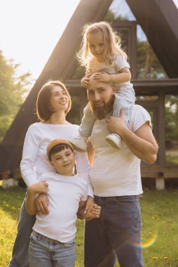Smiling family enjoying time together in front of their new home, representing love, unity, and the joys of family life