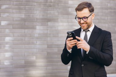 Businessman wearing suit and tie using smartphone app for online banking operation