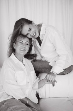 Smiling mother and daughter holding hands and enjoying a tender moment together, showcasing their strong bond and affectionate relationship