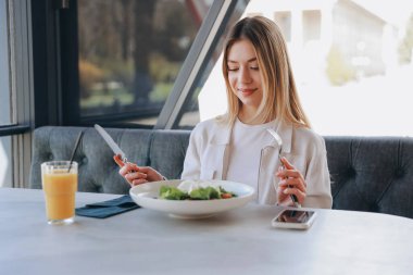 Happy customer eating a fresh salad with mozzarella in a modern restaurant, enjoying a healthy lunch break