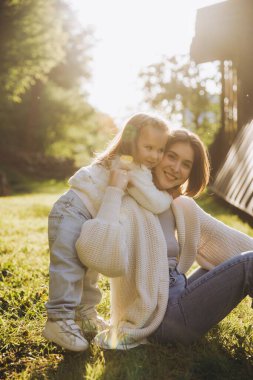 Happy mother and daughter enjoying a playful moment together in a sun drenched garden, creating a heartwarming scene of family love