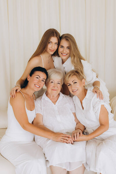Five women of different generations hugging each other, celebrating family bonds and togetherness