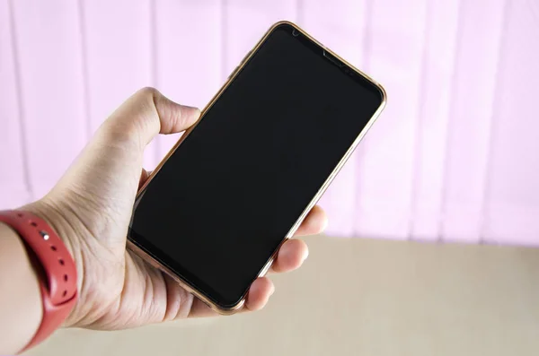 Bir el bir smartphone office arka plan üzerinde tutar.