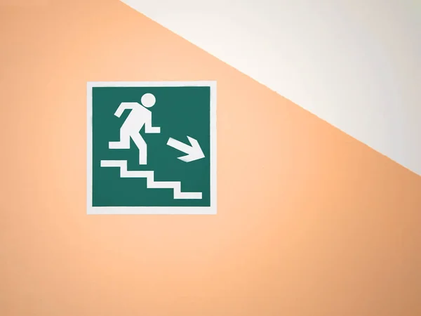 Yeşil işaret boş bir sarı duvara merdiven aşağı