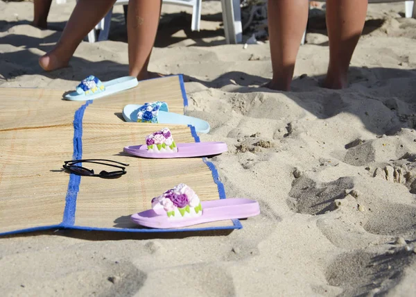 şezlong slates ve tabaklanmış bacaklarını çerçevede plajın kumları üzerinde güneş gözlüğü