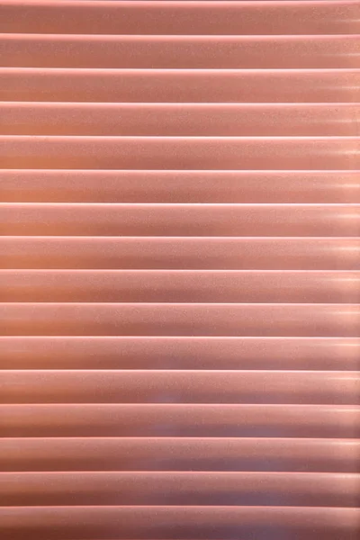 Horizontal pattern of coral venetian blinds in a gradation of color