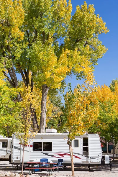 Vintage American mobile home on a camping site in Zion National Park with autumn tree
