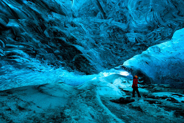 explorer inside an ice cave, vatnajokull national park, Iceland