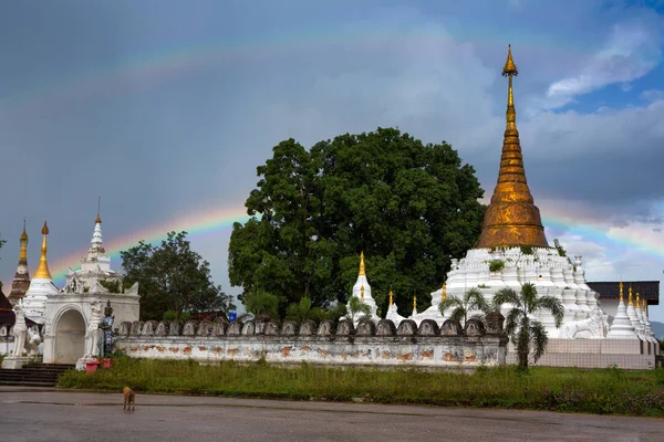 Rainbow over Golden Pagoda, Buddhist architecture at Wat Mon Chamsin in the evening light, Lampang Province, Thailand