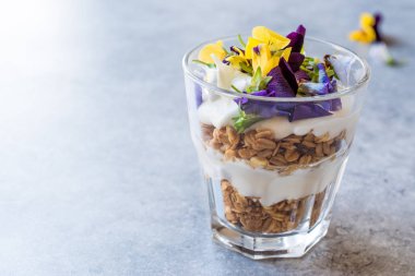 Granola parfe yoğurt ve yenilebilir çiçekler / müsli.