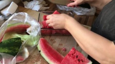 Kadın kırmızı sulu karpuz dilimlerini bıçakla keser