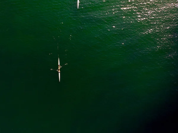 Aerial Drone View of Rowing Team with Canoe in Tranquil Sea / Birds Eye View. Sports in Nature