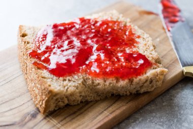 Kırmızı erik reçel marmelat ekmek ile ve cam kase. Organik gıda.