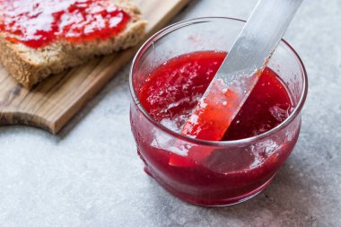 Kırmızı erik reçel marmelat ekmek ile ve cam kase. Organik gıda.