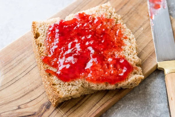 Kırmızı erik reçel marmelat ekmek ile ve cam kase. Organik gıda.