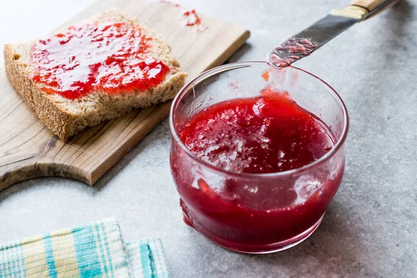 Kırmızı erik reçel marmelat ekmek ile ve cam kase. Organik gıda.