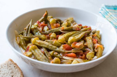 Domates ve soğan dilimleri ile yemek bamya yemek / Bamya. Geleneksel organik gıda.