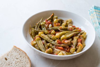 Domates ve soğan dilimleri ile yemek bamya yemek / Bamya. Geleneksel organik gıda.
