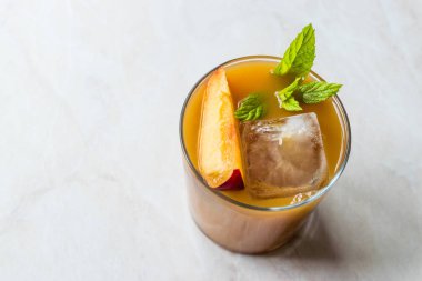 Şeftali Bourbon kokteyl şeftali dilim, nane yaprakları ve buz yaz İçecek ile.