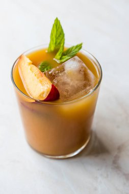 Şeftali Bourbon kokteyl şeftali dilim, nane yaprakları ve buz yaz İçecek ile.