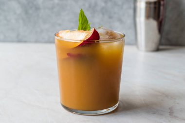 Şeftali Bourbon kokteyl şeftali dilim, nane yaprakları ve buz yaz İçecek ile.