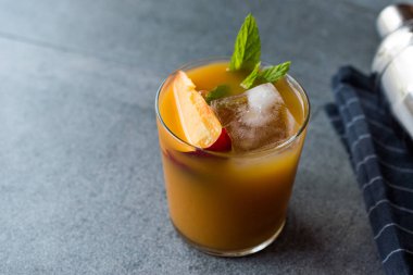 Şeftali Bourbon kokteyl şeftali dilim, nane yaprakları ve buz yaz İçecek ile.