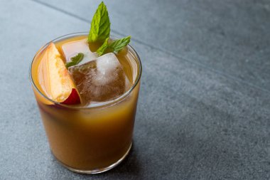 Şeftali Bourbon kokteyl şeftali dilim, nane yaprakları ve buz yaz İçecek ile.