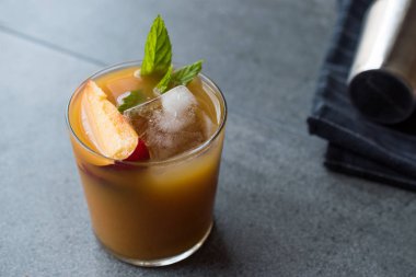 Şeftali Bourbon kokteyl şeftali dilim, nane yaprakları ve buz yaz İçecek ile.