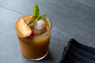 Şeftali Bourbon kokteyl şeftali dilim, nane yaprakları ve buz yaz İçecek ile.