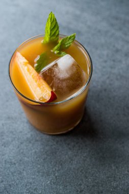 Şeftali Bourbon kokteyl şeftali dilim, nane yaprakları ve buz yaz İçecek ile.