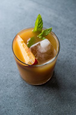 Şeftali Bourbon kokteyl şeftali dilim, nane yaprakları ve buz yaz İçecek ile.