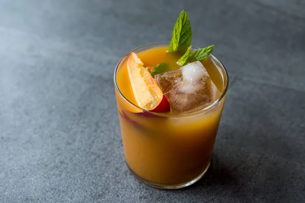 Peach Bourbon Cocktail with Peach Slice, Mint Leaves and Ice. Summer Beverage.