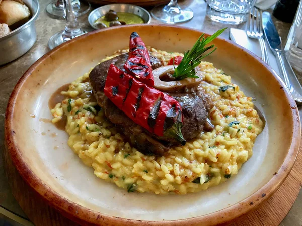 Osso Buco, safran Risotto, kavrulmuş kırmızı biber ve biberiye ile şarap kızarmış dana Shanks. Geleneksel organik gıda.