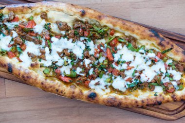 Türk karışık Pide ile kıyılmış et, peynir, sosis (Sucuk), domates ve kırmızı biber salatası ve turşu ile servis. Geleneksel gıda.