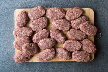 Kıyılmış et Ahşap yüzeyi ile Türk çiğ köfte köfte veya köfte yaptı. Geleneksel gıda.