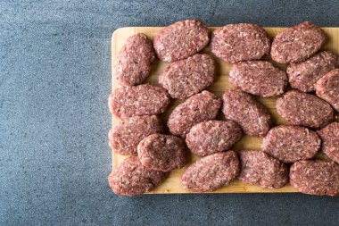 Kıyılmış et Ahşap yüzeyi ile Türk çiğ köfte köfte veya köfte yaptı. Geleneksel gıda.