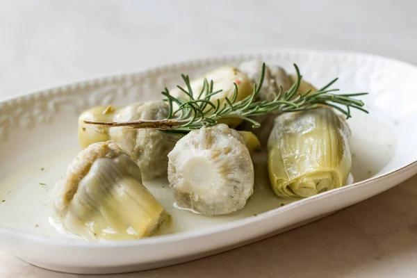 Pickled Artichoke Hearts with Rosemary Marinated in Plate. Organic Food.