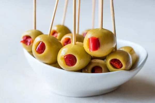 Cocktail Green Olives Stuffed with Red Paprika Pepper Served with Toothpick. Organic Appetizer.